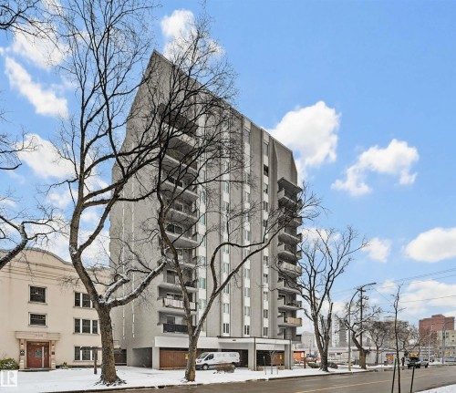 Multi-story building featuring a prominent peaked roofline and an integrated ground-level parking area - 701 10135 116 Street Nw, Edmonton, AB - Outdoor With Facade