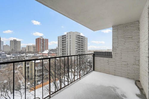 Exterior balcony with a black metal railing and textured white brick wall - 701 10135 116 Street Nw, Edmonton, AB - Outdoor With Exterior