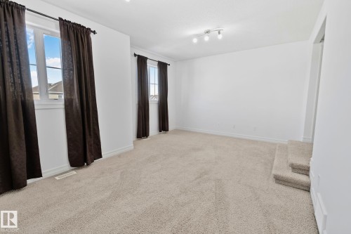 Bright room featuring light-colored carpet, white walls, and track lighting - 1115 61 Street, Edmonton, AB - Indoor Photo Showing Other Room