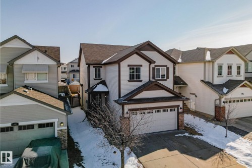 The property features a two-story design with light-colored siding and dark trim accents - 1115 61 Street, Edmonton, AB - Outdoor With Facade