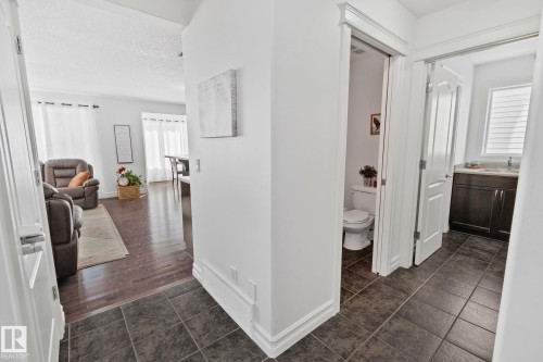 View of the main floor featuring tiled flooring, a powder room with a toilet, and another bathroom with a vanity and sink - 1115 61 Street, Edmonton, AB - Indoor Photo Showing Other Room