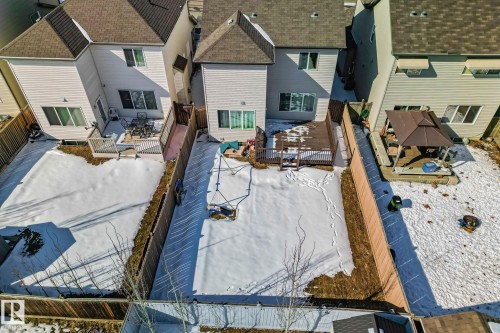 The property features a fenced yard with a deck and swing set - 1115 61 Street, Edmonton, AB - Outdoor