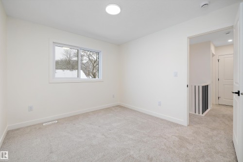 Carpeted room featuring a white-framed window, recessed lighting, and a neutral color palette - 11418 96 Street, Edmonton, AB - Indoor Photo Showing Other Room