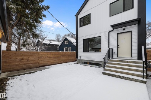 Modern exterior featuring white horizontal siding, black trim, and a prominent entry door - 11918 93 Street, Edmonton, AB - Outdoor