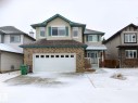 Two-story residence featuring a combination of brick and siding finishes, an attached front-facing two-car garage, multiple upper-level windows with shutters, and a covered front entry - 59 Rue Monette, Beaumont, AB  - Outdoor With Facade 