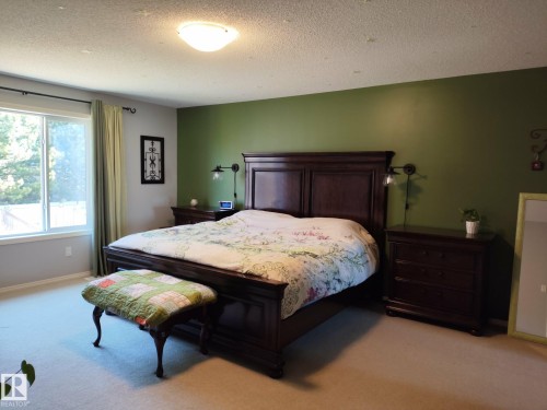 Wall-to-wall carpeting with a large window featuring a white frame - 59 Rue Monette, Beaumont, AB - Indoor Photo Showing Bedroom