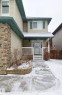 Exterior featuring light-colored siding, contrasting brick accents, a covered front porch with white railings, and a concrete walkway - 59 Rue Monette, Beaumont, AB  - Outdoor 