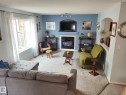 Living area featuring a prominent fireplace with a white mantel and integrated media niche - 59 Rue Monette, Beaumont, AB  - Indoor Photo Showing Living Room With Fireplace 