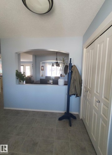 Entryway featuring durable tile flooring and a bi-fold closet with panel doors - 59 Rue Monette, Beaumont, AB - Indoor