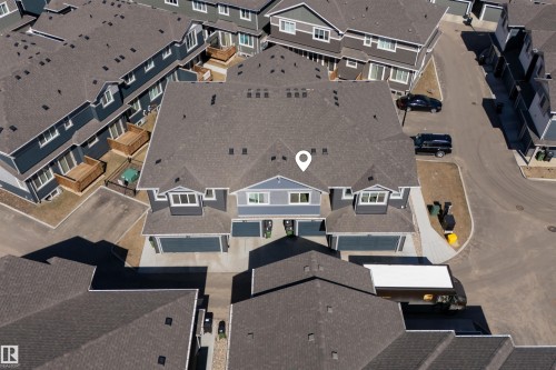 Townhome community featuring multi-story residences with dark gray shingle roofing and light gray siding - 51 603 Orchards Boulevard Sw, Edmonton, AB - Outdoor