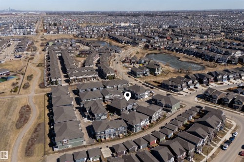 Aerial perspective showcasing a residential development with multiple housing units - 51 603 Orchards Boulevard Sw, Edmonton, AB - Outdoor With View