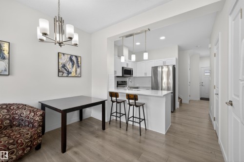 Bright dining area with wood-finish flooring and a contemporary chandelier - 51 603 Orchards Boulevard Sw, Edmonton, AB - Indoor