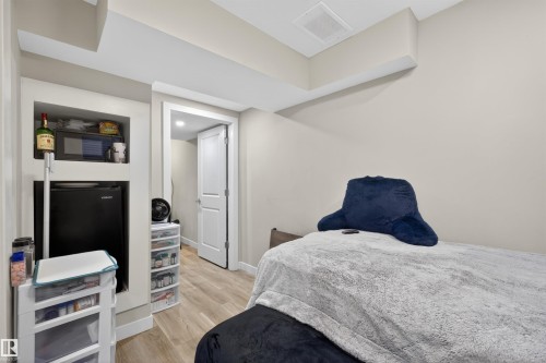 Neutral wall paint with wood-finish flooring - 51 603 Orchards Boulevard Sw, Edmonton, AB - Indoor Photo Showing Bedroom