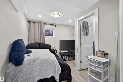 Compact room featuring wood-finish flooring, recessed lighting, and a white interior door - 51 603 Orchards Boulevard Sw, Edmonton, AB - Indoor
