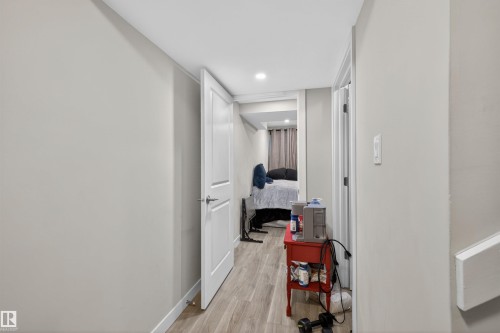 Hallway with light gray walls, wood-finish flooring, white baseboards, and recessed lighting - 51 603 Orchards Boulevard Sw, Edmonton, AB - Indoor Photo Showing Other Room