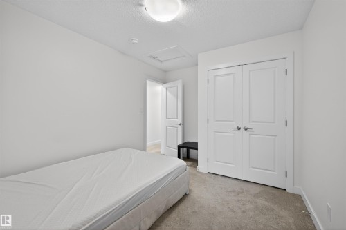 Bedroom featuring light-colored carpeting, white walls, and a ceiling-mounted light fixture - 51 603 Orchards Boulevard Sw, Edmonton, AB - Indoor Photo Showing Bedroom
