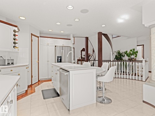 Kitchen featuring white cabinetry, light countertops, a kitchen breakfast bar, recessed lighting, and a kitchen island with sink - 29 Oakdale Place, St. Albert, AB - Indoor