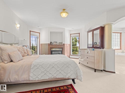 Bedroom with multiple windows, a glass covered fireplace, and carpet - 29 Oakdale Place, St. Albert, AB - Indoor Photo Showing Bedroom