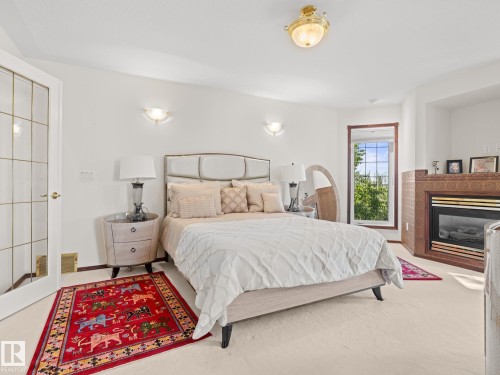 Bedroom with a glass covered fireplace and carpet floors - 29 Oakdale Place, St. Albert, AB - Indoor Photo Showing Bedroom