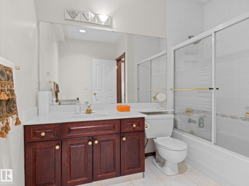 Bathroom featuring bath / shower combo with glass door, light tile patterned floors, and vanity - 29 Oakdale Place, St. Albert, AB - Indoor Photo Showing Bathroom