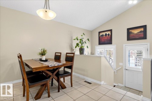 The property features a dining area with tile flooring, a vaulted ceiling, and a modern light fixture - 3518 18 Street, Edmonton, AB - Indoor Photo Showing Dining Room