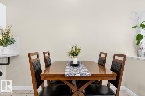 The dining area features a wooden dining table paired with four dining chairs, and a tiled floor - 3518 18 Street, Edmonton, AB - Indoor Photo Showing Dining Room