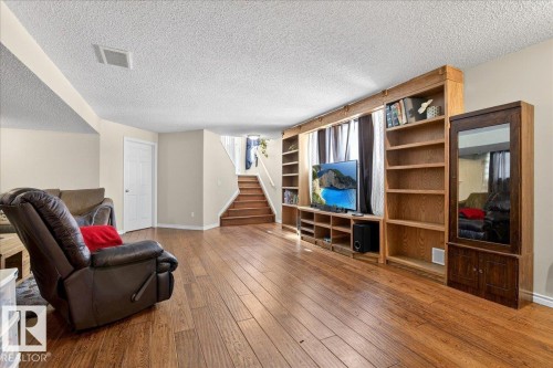 This expansive living area features hardwood floors and a built-in media center with shelving - 3518 18 Street, Edmonton, AB - Indoor Photo Showing Living Room