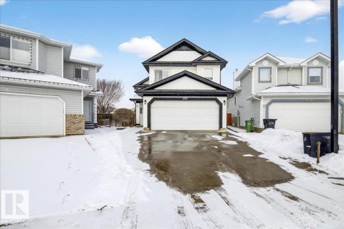 The property features a two-story exterior with white siding and dark trim, a two-car garage, and a paved driveway - 3518 18 Street, Edmonton, AB - Outdoor With Facade