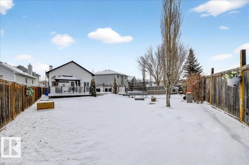 The property features a large backyard with a wooden fence, mature trees, and a spacious deck - 3518 18 Street, Edmonton, AB - Outdoor
