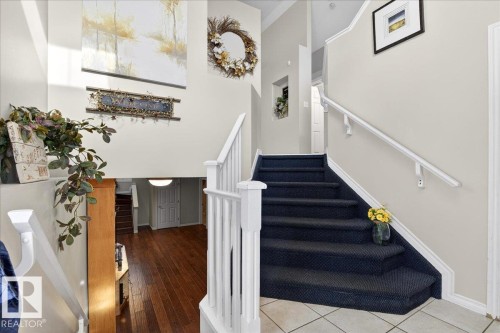 Carpeted staircase with white railings, leading to a tiled entryway - 3518 18 Street, Edmonton, AB - Indoor Photo Showing Other Room