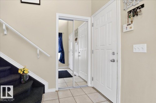 Entryway featuring tile flooring, a white paneled door, and a staircase with dark carpet - 3518 18 Street, Edmonton, AB - Indoor Photo Showing Other Room