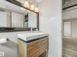 Bathroom vanity featuring a rectangular vessel sink, wall-mounted faucet, and wood-finish cabinetry with silver hardware - 