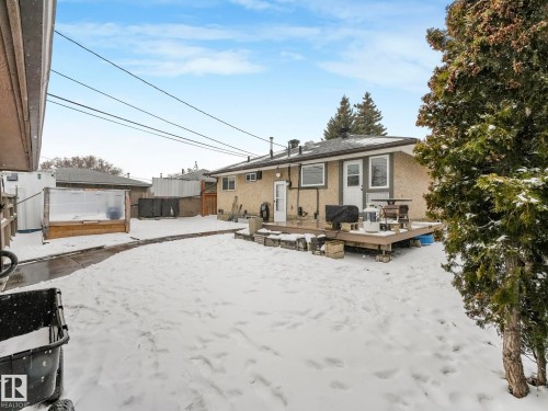 Rear exterior featuring a wood-deck patio and a detached greenhouse structure - 7607 70 Avenue, Edmonton, AB 