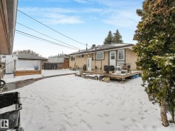 Rear exterior featuring a wood-deck patio and a detached greenhouse structure - 