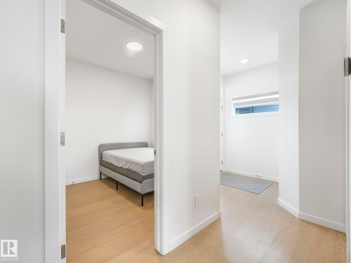 Bright interior hallway with wood-finish flooring - 4851 Kinney Road, Edmonton, AB - Indoor