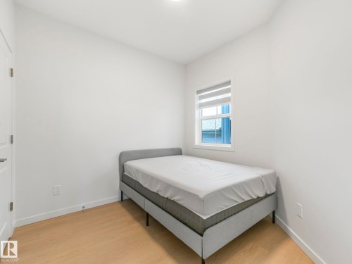 Room featuring light wood-finish flooring, white walls, and a window with blinds - 4851 Kinney Road, Edmonton, AB - Indoor Photo Showing Bedroom