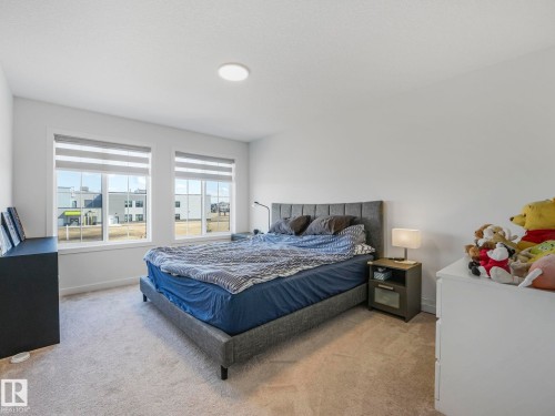 Spacious bedroom featuring light-colored carpeting, white painted walls, and a recessed ceiling light fixture - 4851 Kinney Road, Edmonton, AB - Indoor Photo Showing Bedroom