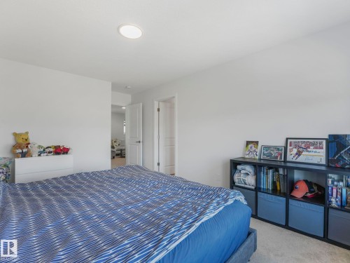 Carpeted room featuring recessed lighting, a built-in shelf unit, and a white interior door - 4851 Kinney Road, Edmonton, AB - Indoor Photo Showing Bedroom