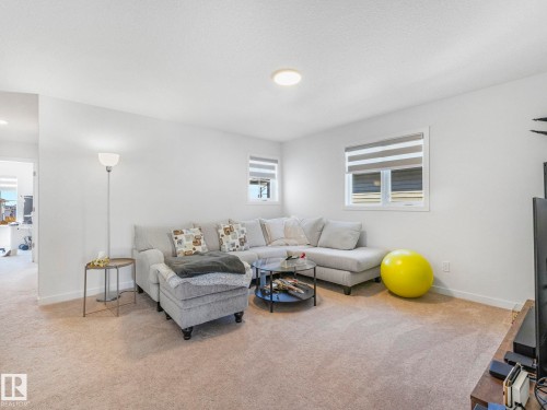 Carpeted interior space featuring white walls and multiple windows with horizontal blinds - 4851 Kinney Road, Edmonton, AB - Indoor Photo Showing Living Room