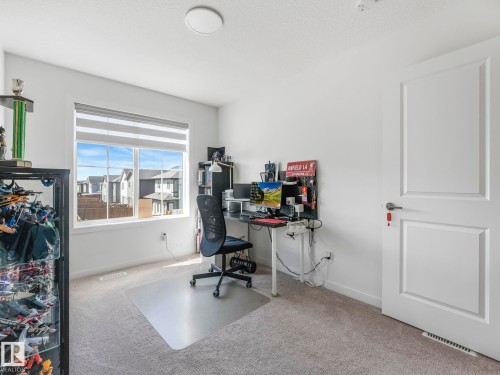 Bright room featuring a large window with horizontal blinds, neutral carpeting, and a white interior door - 4851 Kinney Road, Edmonton, AB - Indoor Photo Showing Office