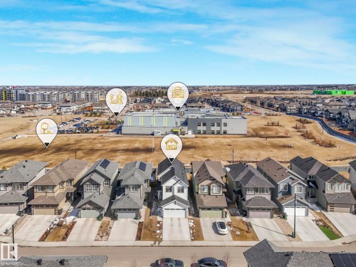 Aerial perspective showcasing a residential street with detached homes, each featuring individual driveways and attached garages - 4851 Kinney Road, Edmonton, AB - Outdoor With View