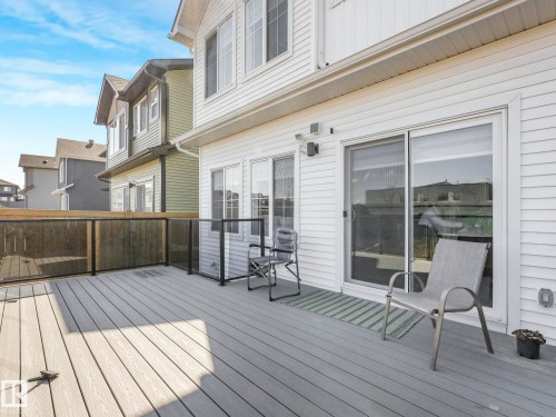 Spacious outdoor deck featuring composite decking, glass panel railings, and a privacy fence - 4851 Kinney Road, Edmonton, AB - Outdoor With Deck Patio Veranda With Exterior