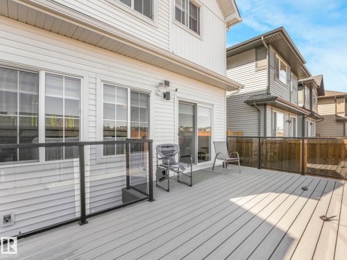 Spacious outdoor deck featuring composite decking and glass panel railing - 4851 Kinney Road, Edmonton, AB - Outdoor With Deck Patio Veranda With Exterior