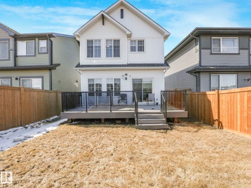Rear elevation featuring white siding and a multi-level deck with glass panel railings - 4851 Kinney Road, Edmonton, AB - Outdoor With Deck Patio Veranda