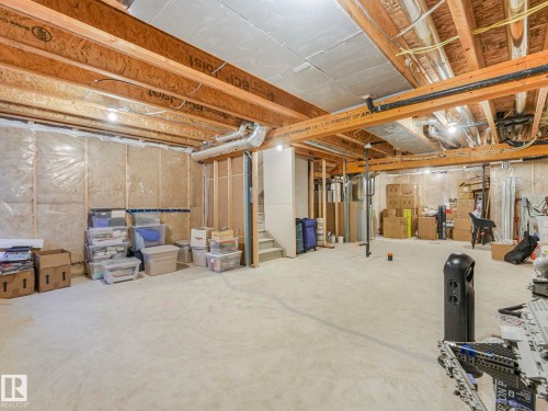 Unfinished basement featuring exposed wood joists, concrete flooring, and insulated walls - 4851 Kinney Road, Edmonton, AB - Indoor Photo Showing Basement