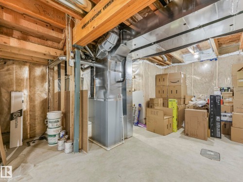 Unfinished basement space featuring exposed wooden beams, concrete flooring, and visible ductwork - 4851 Kinney Road, Edmonton, AB - Indoor Photo Showing Basement