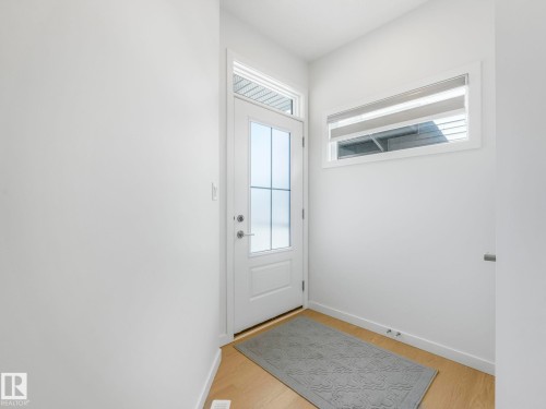 Entryway featuring a glass-paneled door, transom window, and wood-finish flooring - 4851 Kinney Road, Edmonton, AB - Indoor Photo Showing Other Room
