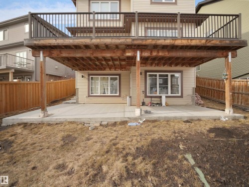 The property features a raised wooden deck with dark railings, a ground-level concrete patio, and a fenced yard - 4231 Charles Close, Edmonton, AB - Outdoor With Deck Patio Veranda With Exterior