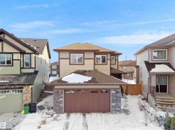 The property features a two-story design with a two-car garage, a brown roof, and stone facade accents - 