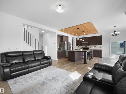 The property features an open-concept living area with light-toned flooring and white walls - 4231 Charles Close, Edmonton, AB - Indoor Photo Showing Living Room